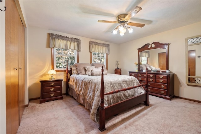 carpeted bedroom featuring ceiling fan and a closet