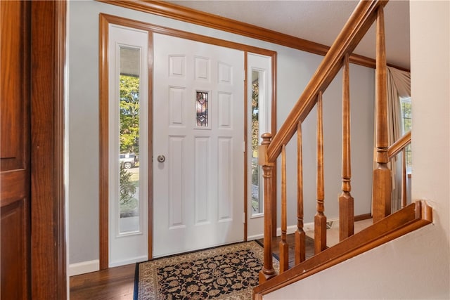 foyer with ornamental molding, dark hardwood / wood-style flooring, a wealth of natural light, and a textured ceiling