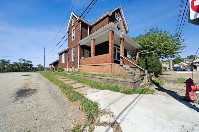 view of side of property featuring covered porch