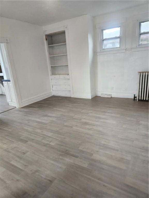 2622 Milburn St, Mckeesport, PA 15132 - interior space featuring baseboards, radiator heating unit, wood finished floors, and a wealth of natural light