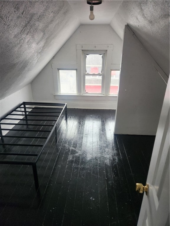 bonus room with vaulted ceiling, dark hardwood / wood-style flooring, and a textured ceiling