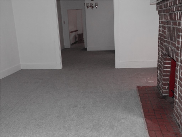 unfurnished living room featuring a brick fireplace and dark colored carpet