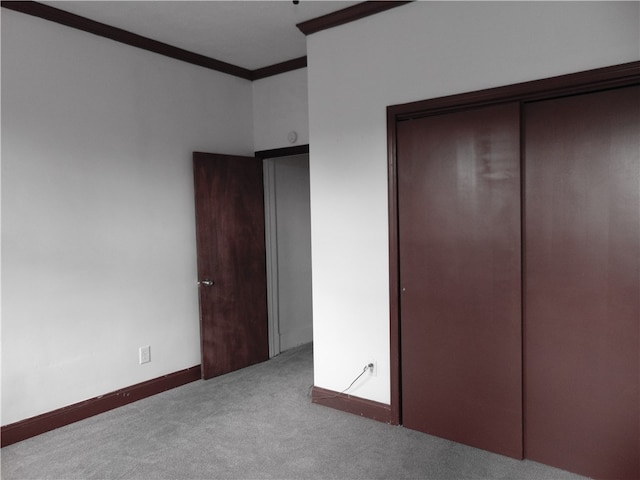 unfurnished bedroom featuring a closet, light carpet, and ornamental molding