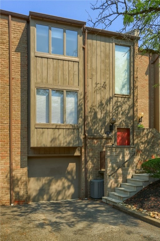 view of front of property with central air condition unit and a garage