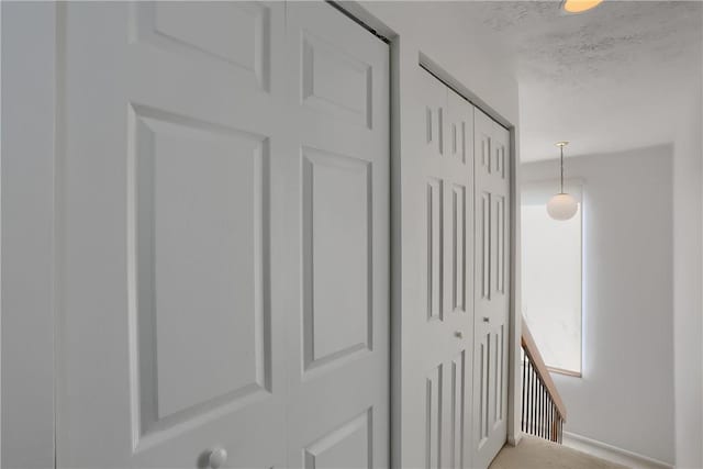 hall with a textured ceiling