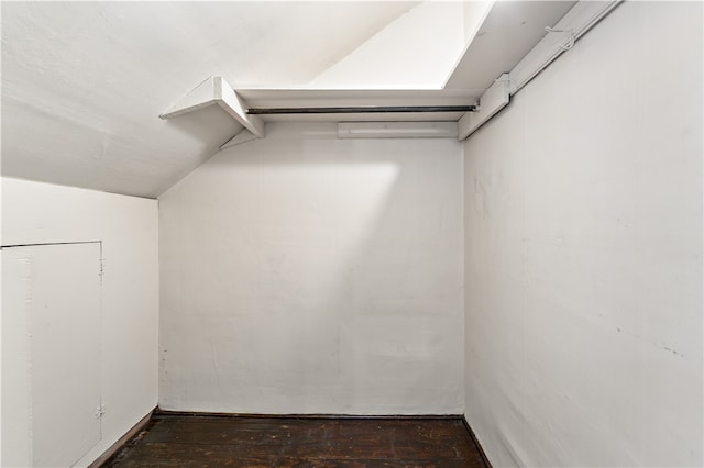 walk in closet featuring dark wood-type flooring and lofted ceiling