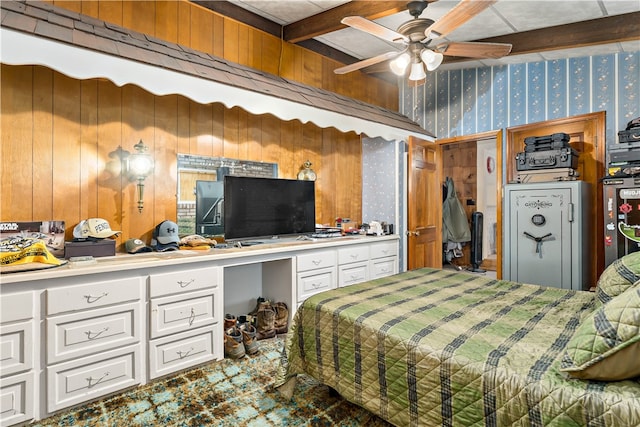 bedroom with built in desk, ceiling fan, beamed ceiling, and wooden walls