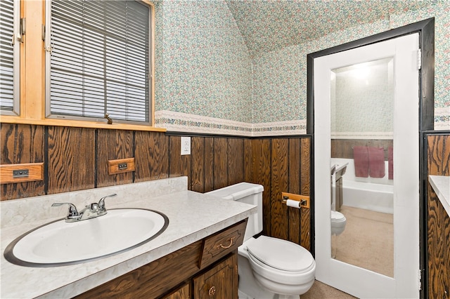 bathroom featuring wood walls, toilet, and vanity