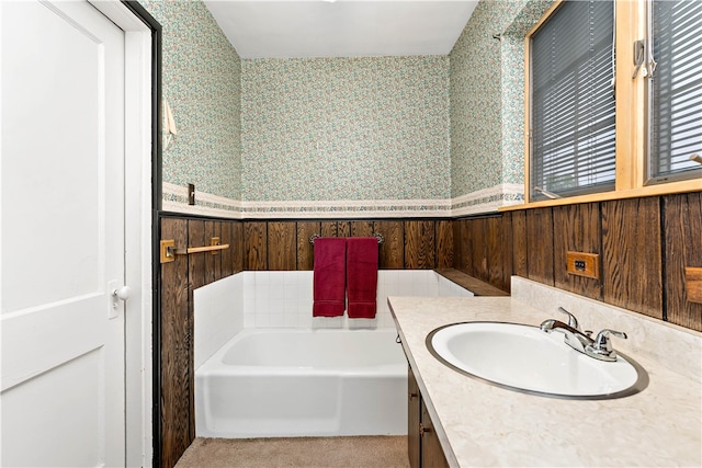 bathroom with vanity, wood walls, and a bathtub