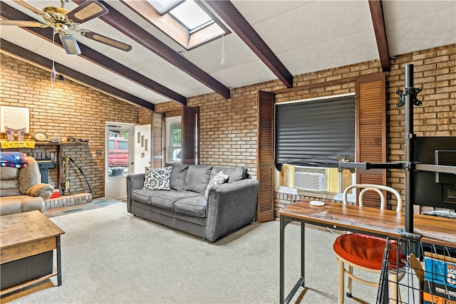 carpeted living room with a fireplace, lofted ceiling with skylight, brick wall, and ceiling fan