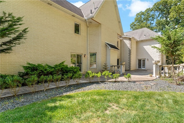 view of side of property featuring a patio area and a yard