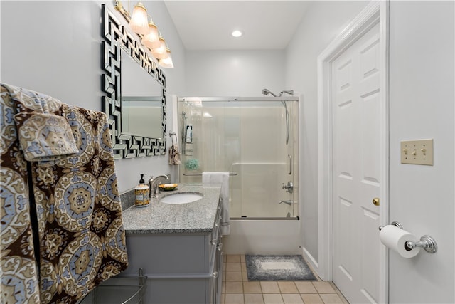 bathroom featuring combined bath / shower with glass door, vanity, and tile patterned flooring