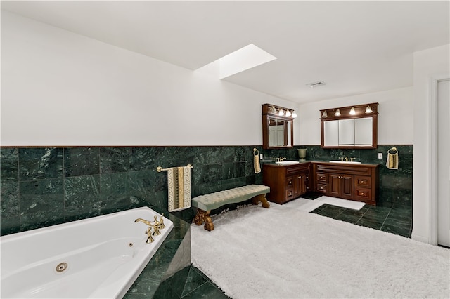 bathroom with vanity, tile walls, tile patterned flooring, and tiled bath