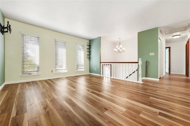 spare room featuring a notable chandelier and wood-type flooring