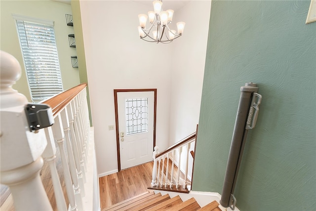 entryway with hardwood / wood-style floors and a notable chandelier