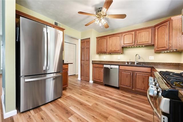 kitchen with stainless steel appliances, ceiling fan, light hardwood / wood-style floors, and sink