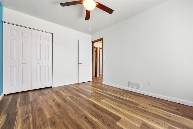 unfurnished bedroom with hardwood / wood-style floors, ceiling fan, and a closet