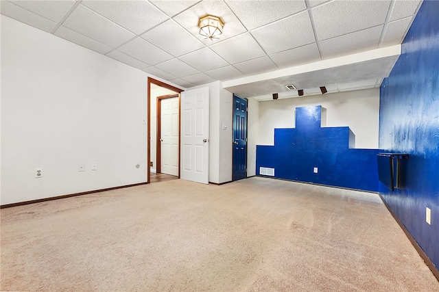 carpeted spare room featuring a paneled ceiling