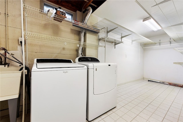 clothes washing area featuring washing machine and clothes dryer and sink