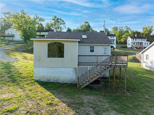 back of property featuring a lawn and a deck