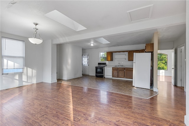 unfurnished living room featuring a skylight, dark hardwood / wood-style floors, and sink