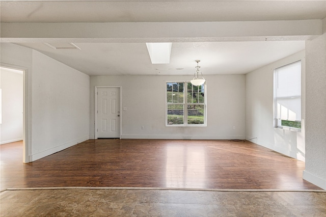 spare room with wood-type flooring and a skylight