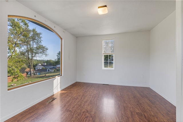 unfurnished room with dark hardwood / wood-style flooring