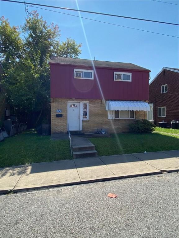 2608 Highland Ave, Mckeesport, PA 15132 - view of property with brick siding and a front yard