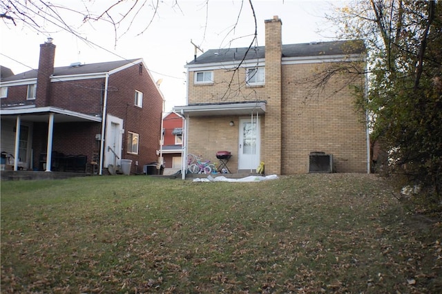 2608 Highland Ave, Mckeesport, PA 15132 - rear view of house with brick siding, a chimney, a yard, and cooling unit