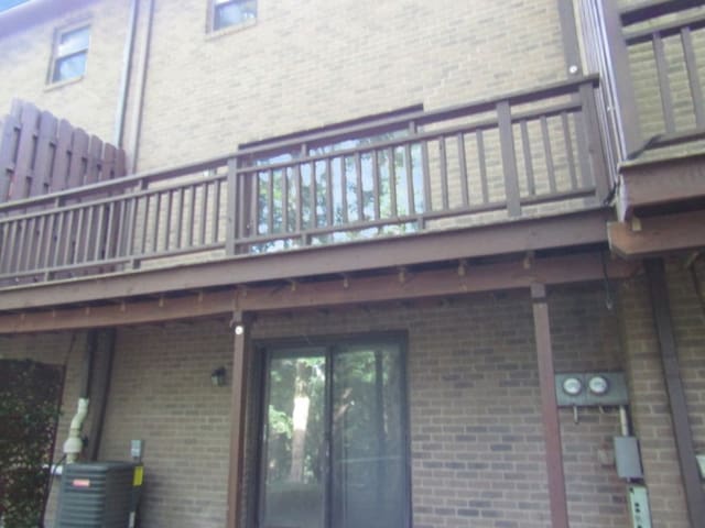 view of side of property featuring central AC unit and a balcony