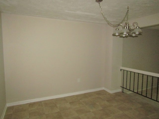 empty room featuring a notable chandelier