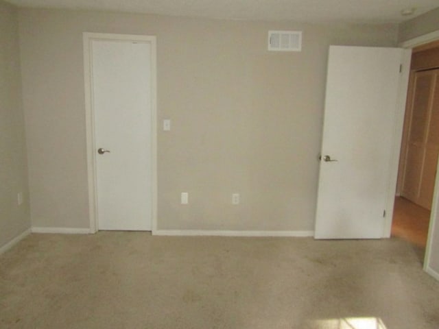 unfurnished room featuring light carpet