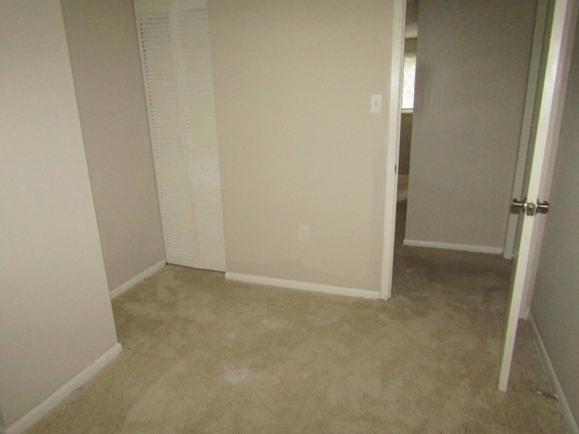 unfurnished bedroom featuring a closet and light carpet