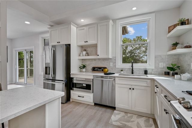 kitchen featuring plenty of natural light, stainless steel appliances, and white cabinetry