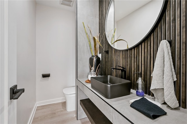 bathroom with toilet, hardwood / wood-style flooring, and vanity