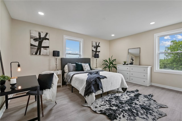 bedroom with light wood-type flooring and multiple windows