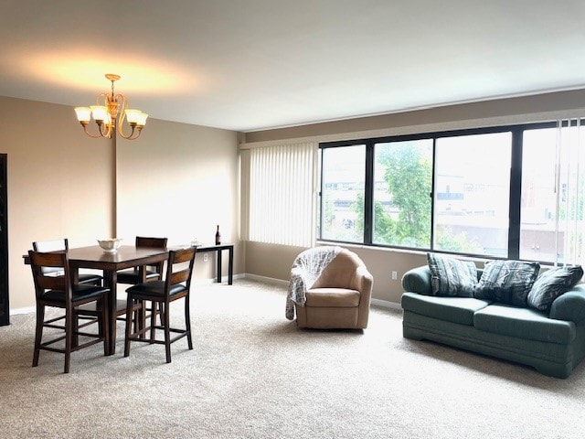 dining space featuring carpet and a chandelier