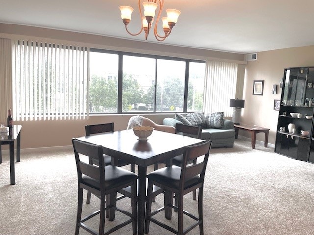 dining room featuring carpet flooring and an inviting chandelier