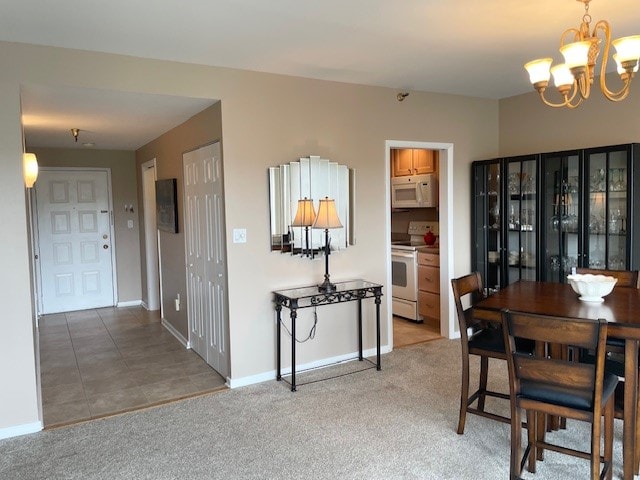 dining space with carpet flooring and an inviting chandelier