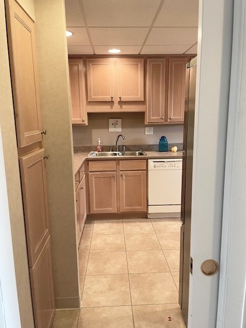 kitchen featuring dishwasher, sink, light tile patterned flooring, and a drop ceiling