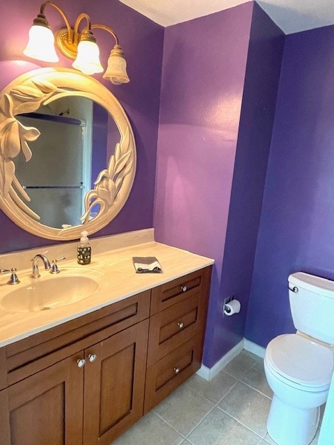 bathroom with tile patterned flooring, vanity, and toilet