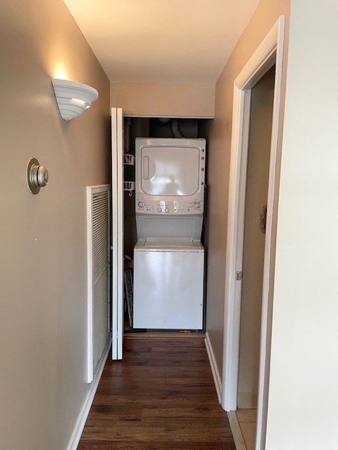 interior space with dark wood-type flooring and stacked washer / drying machine