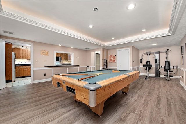 playroom with a tray ceiling, pool table, and hardwood / wood-style flooring