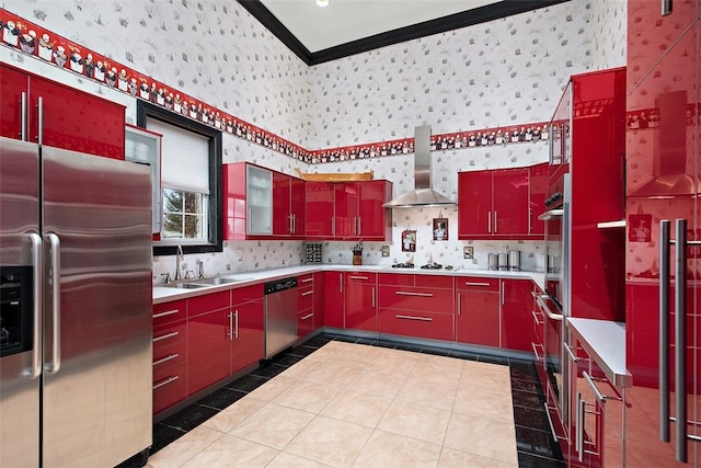 kitchen with light tile patterned floors, stainless steel appliances, sink, wall chimney exhaust hood, and ornamental molding