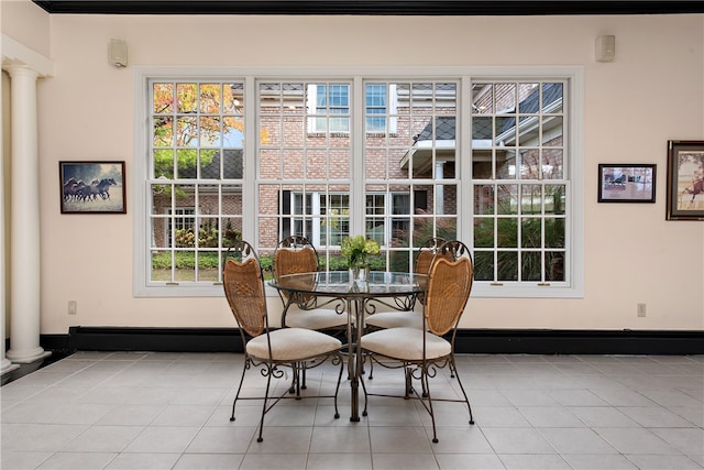 tiled dining area featuring decorative columns and plenty of natural light