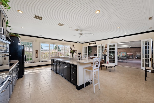 kitchen with black appliances, a kitchen island with sink, wood ceiling, ornamental molding, and ceiling fan