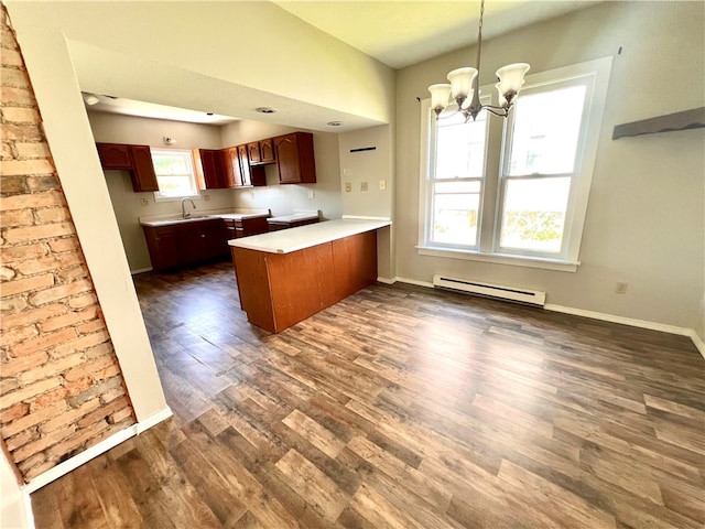 kitchen with baseboard heating, dark hardwood / wood-style flooring, a chandelier, kitchen peninsula, and pendant lighting