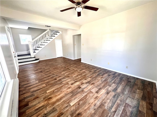 unfurnished living room featuring dark wood-type flooring and ceiling fan