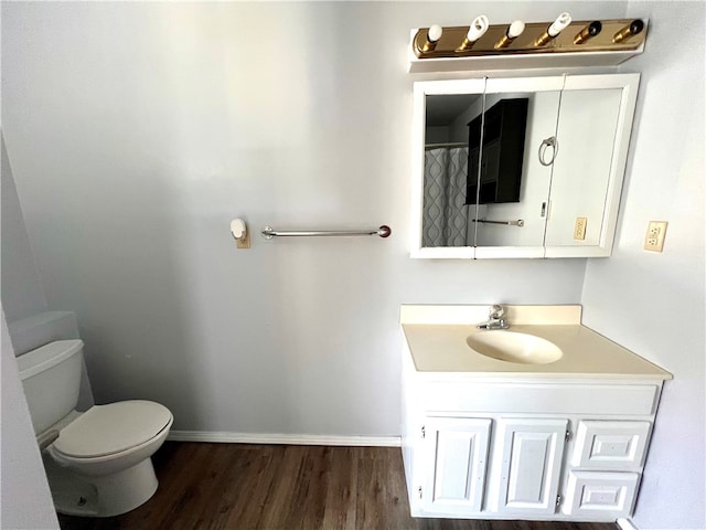 bathroom featuring wood-type flooring, toilet, and vanity