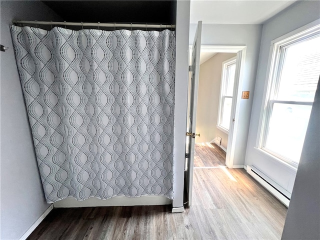 bathroom with hardwood / wood-style floors, plenty of natural light, and baseboard heating